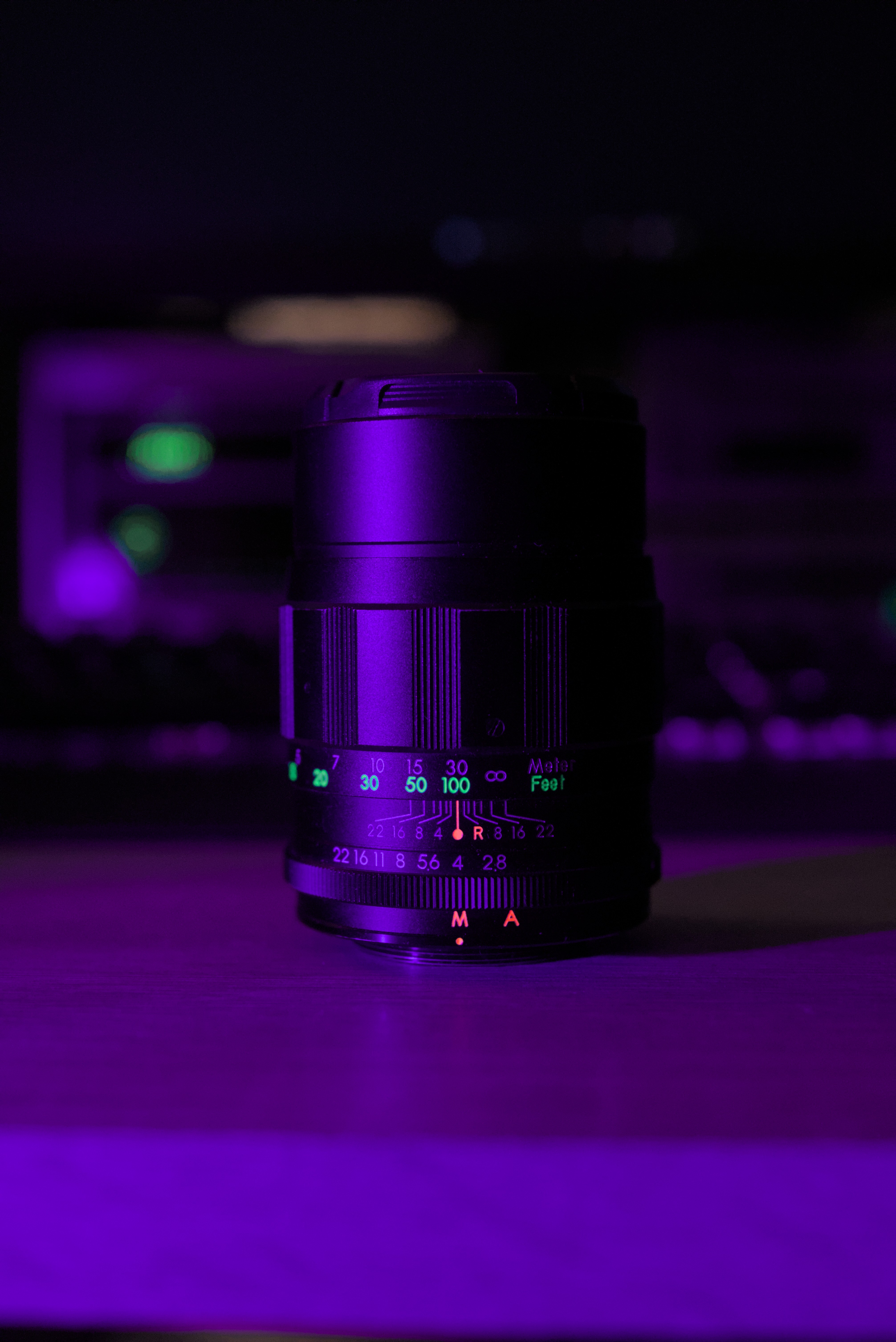 an image of an old camera lens in a violet light, showcasing its beautiful fluorescent details.